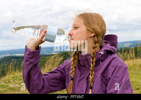 Porträt der jungen blonden Frau Outdoor-Trinkwasser Stockfoto