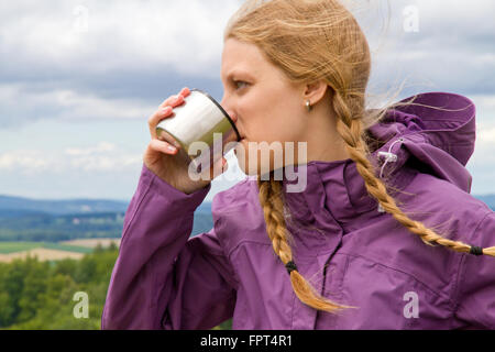 Junge Frau ein Getränk aus einem Becher Stockfoto