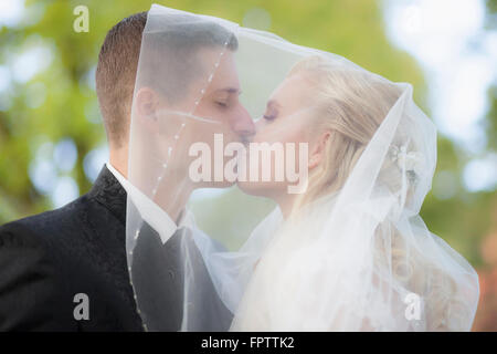Nahaufnahme einer Braut und Bräutigam küssen unter Schleier, Ammersee, Upper Bavaria, Bavaria, Germany Stockfoto