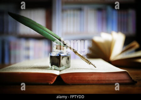 Federkiel auf ein altes Buch in einer Bibliothek Stockfoto