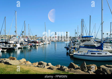 Hafen Sie mit großen Mond über Leuchtturm. Boote angedockt. Stockfoto