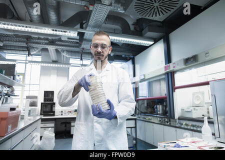 Wissenschaftler halten Stapel von Petrischalen im Labor Apotheke, Freiburg Im Breisgau, Baden-Württemberg, Deutschland Stockfoto