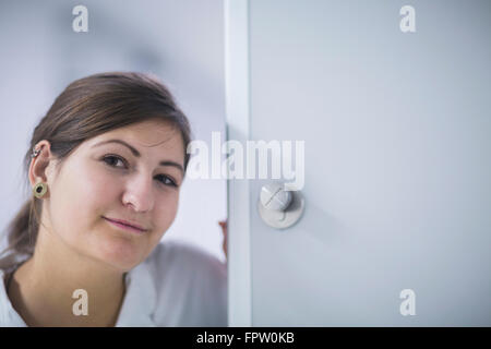Porträt einer jungen Ärztin an Tür im Krankenhaus, Freiburg Im Breisgau, Baden-Württemberg, Deutschland Stockfoto