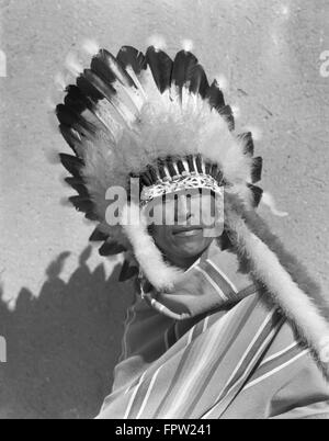 1930ER JAHRE PORTRAIT INDIANER INDISCHER MANN TRAGEN VOLLE GEFIEDERTEN KOPFSCHMUCK KRIEG MOTORHAUBE SAN ILDEFONSO PUEBLO NEW MEXICO USA Stockfoto