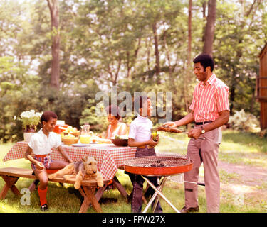 1960ER 1970ER JAHREN AFROAMERIKANISCHE FAMILIE HINTERHOF BAR-B-QUE VATER MUTTER SOHN UND TOCHTER IM FREIEN Stockfoto