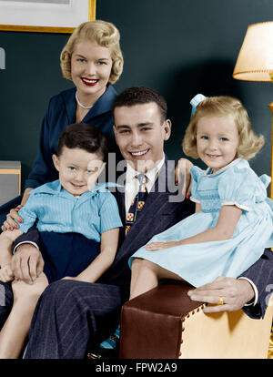 1940S 1950S FAMILIE VON VIER PORTRÄT SITZEN IM WOHNZIMMER STUHL BLICK IN DIE KAMERA Stockfoto