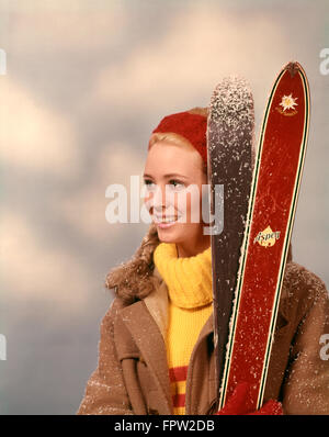 1960S 1970S PORTRAIT FRAU ROTEN STIRNBAND GELBEN ROLLKRAGEN PULLOVER HOLDING PAAR SKIS SKI Stockfoto