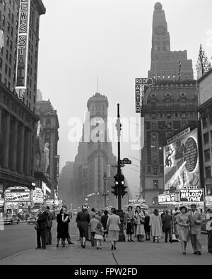 1940ER JAHRE TIMES SQUARE IN DER DÄMMERUNG NACHT BLICK NACH SÜDEN VOM DUFFY SQUARE IN RICHTUNG NEW YORK TIMES BUILDING FUßGÄNGER NEON FILM FESTZELTE Stockfoto