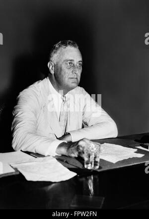 1930S 1940S PORTRÄT FRANKLIN DELANO ROOSEVELT FDR 32. US-PRÄSIDENT SITZEN AM SCHREIBTISCH MIT PAPIEREN Stockfoto