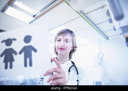 Junge Ärztin hält Bild des Babys im Krankenhaus, Freiburg Im Breisgau, Baden-Württemberg, Deutschland Stockfoto