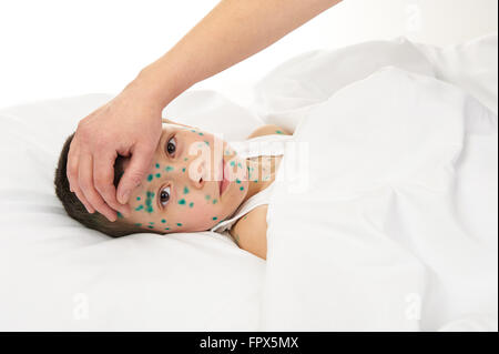 kranke Kind im Bett hat das Virus auf Haut, Mutters Hand berührt die Stirn Stockfoto