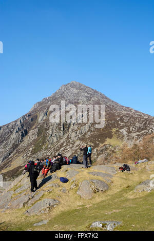 Eine Gruppe von Wanderern ruhen und Ejoying die Ansicht nach unten den Nant Ffrancon Pass in Snowdonia mit Stift yr Ole Wen Berg. Stockfoto