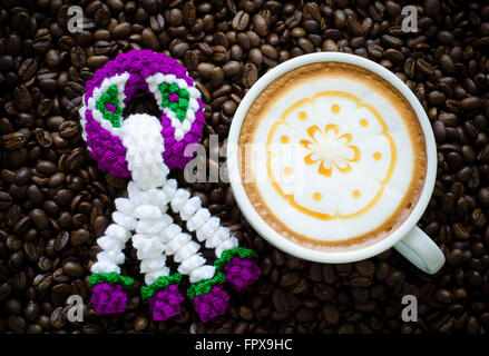 Kranz, stricken und Latte Art auf Kaffeebohne Hintergrund Stockfoto