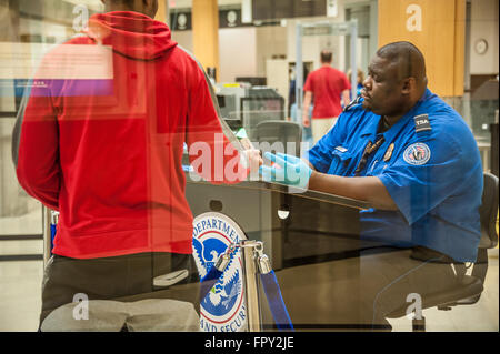 TSA Agent prüft, ID-Dokumente im Homeland Security Checkpoint in Atlanta International Airport in Atlanta, Georgia. (USA) Stockfoto