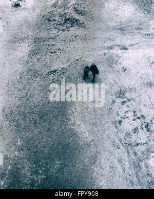 Menschen zu Fuß auf einem schneebedeckten Weg im Winter von einer Antenne Position und einem fotografischen Blickwinkel blickte auf die Stockfoto