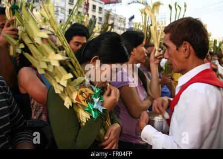 Manila, Philippinen. 20. März 2016. Ein Anhänger mit Palmwedeln Empfang der Heiligen Kommunion in Quiapo, Manila. Katholische Gläubige strömten Quiapo Kirche in Manila, als sie Palmwedel winken, während von Priester während der Messe am Palmsonntag gesegnet. © J Gerard Seguia/Pacific Press/Alamy Live-Nachrichten Stockfoto