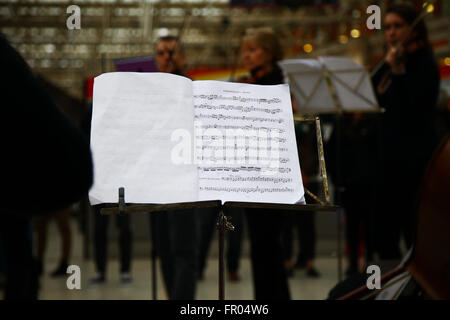 London, UK. 20. März 2016. Pendler an der Waterloo Station, London, sind zu einem Violinkonzert von Royal Orchester Gesellschaft Großbritanniens älteste Laienorchester Bachs Geburtstag behandelt. Stockfoto