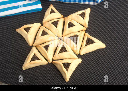 Ashkenazi Juden Essen auf Purim dreieckige Gebäck namens Hamantaschen (Hamans Taschen) oder Oznei Haman (Hamans Ohren) Stockfoto