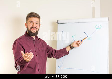 Junge bärtige Mann durch das Flipchart präsentieren Stockfoto