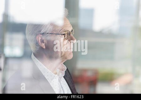 Nachdenklich senior Geschäftsmann Bürofenster mit Blick Stockfoto