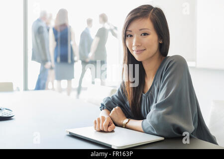 Porträt lächelnd Geschäftsfrau mit Laptop im Konferenzraum Stockfoto