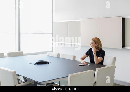 Nachdenklich Geschäftsfrau mit digital-Tablette im Konferenzraum Stockfoto