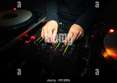 Hände eines weiblichen DJ mischen von zwei Spuren auf professionelles Audioequipment Stockfoto