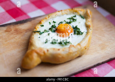 Georgische Traditionsgericht Khachapuri-Teig mit Ei, Butter und Käse Stockfoto