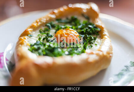 Makroaufnahme einer georgischen Traditionsgericht Khachapuri - Teig mit Ei, Butter und Käse Stockfoto