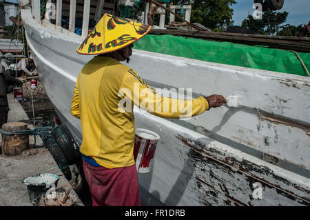 Männer malen Boote im Hafen von Paotere. Der Paotere Hafen bekannt, wie eine alte port und eines Tourismus-Standort in Makassar. Stockfoto