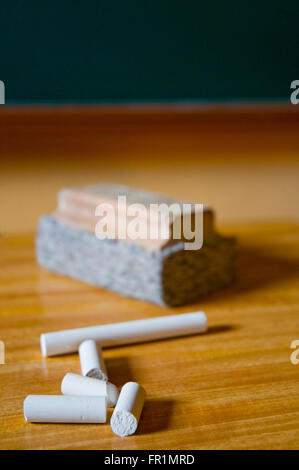 Kreiden und Board Duster auf des Lehrers Tisch. Stockfoto