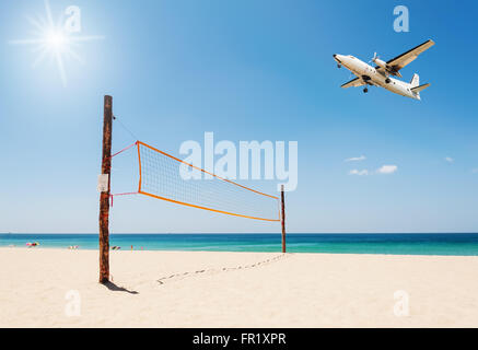 Volleyball net auf den Strand und das Flugzeug mit tropischen Meer und über das Licht die Sonne Stockfoto