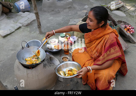 Traditionelle Art der Zubereitung von Essen am offenen Feuer in der alten Küche in einem Dorf, Kumrokhali, Westbengalen, Indien Stockfoto