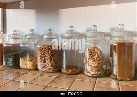 Reihe von großen Glas Küche Gläser in einer Reihe mit roten grünen Linsen und Nudeln Muscheln tagatelli Stockfoto