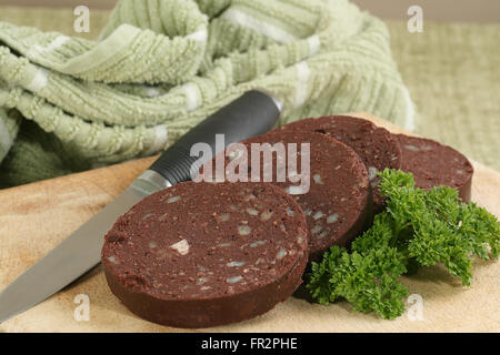 vier Scheiben frische Blutwurst auf ein Schneidbrett aus Holz Stockfoto