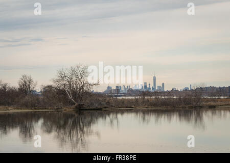 Blick über die West-Teich im Jamaica Bay Wildlife Refuge, New York im Winter mit der Innenstadt von Manhattan-Skyline in der Ferne Stockfoto