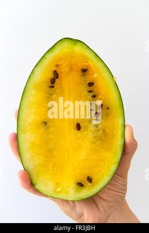 Eine Wassermelone halbieren, in der Hand einer jungen Frau, isoliert auf weiss gehalten. Stockfoto