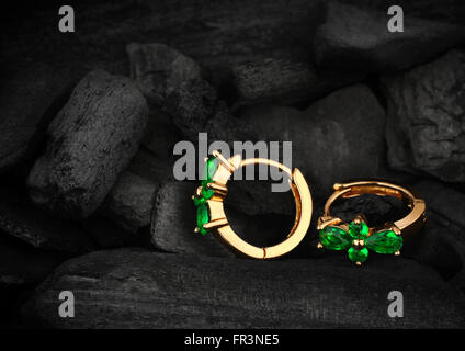 Schmuck Ohrring s mit Edelstein Smaragd auf dunklen Kohle Hintergrund Stockfoto