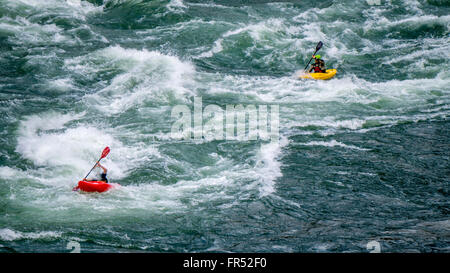 Kajakfahrer Navigation durch die White Water Rapids und Felsbrocken in den Fraser River, da der Fluss schlängelt sich durch den Fraser Canyon in BC, Kanada Stockfoto