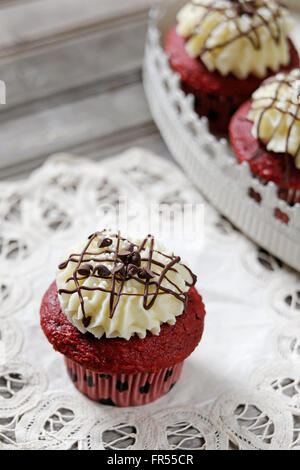 Cupcakes. Rev Velvet Cupcakes mit Frischkäse Zuckerguss und Chocolate Chips Stockfoto