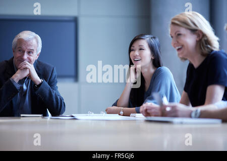 Geschäftsfrauen, die lachend in treffen Stockfoto