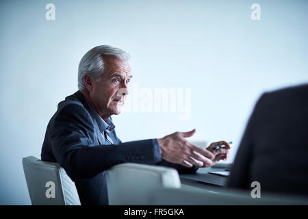 Leitenden Geschäftsmann gestikulieren und reden in treffen Stockfoto