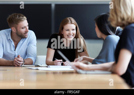 Lächelnde Geschäftsleute sprechen in treffen Stockfoto