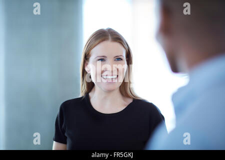 Geschäftsfrau im Gespräch mit Geschäftsmann lächelnd Stockfoto