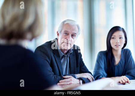 Leitenden Geschäftsmann hören in treffen Stockfoto