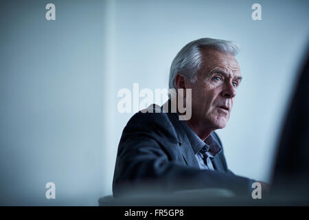 Ernst senior Geschäftsmann hören in treffen Stockfoto