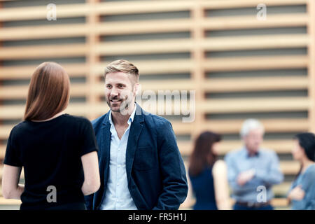 Geschäftsmann und Geschäftsfrau in Lobby sprechen Stockfoto