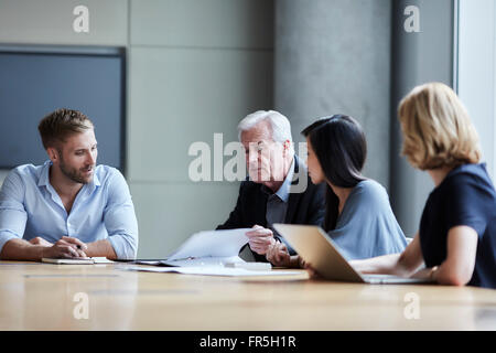 Business-Leute diskutieren Schreibarbeit im Konferenzraum Stockfoto