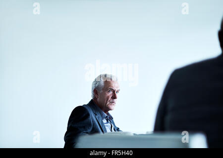 Ernst senior Geschäftsmann hören in treffen Stockfoto