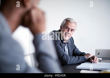 Leitenden Geschäftsmann hören in treffen Stockfoto